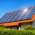 Solaranlage auf einem Hausdach unter dem strahlend blauen Himmel, mit der Reflektion der Sonne